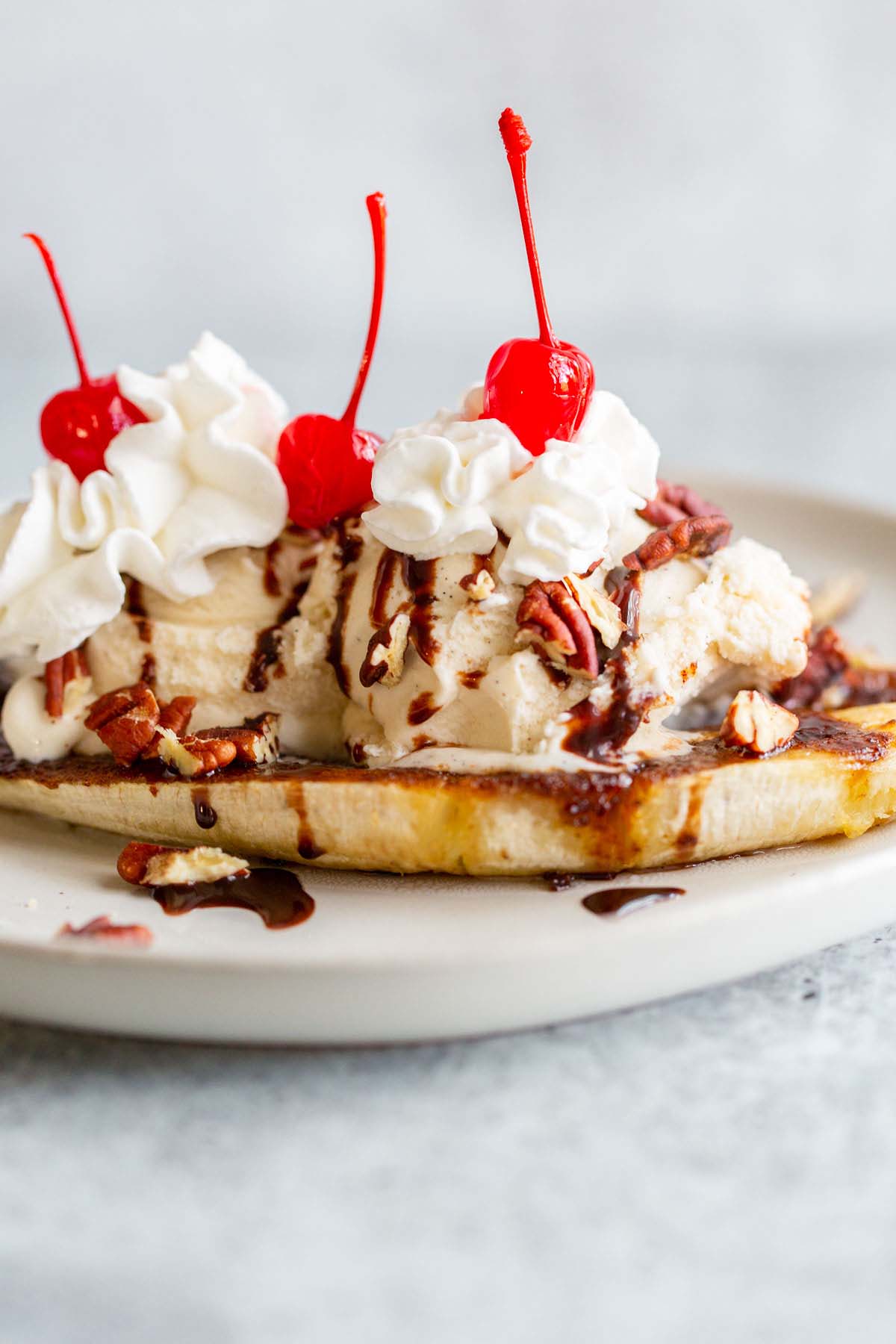 Air fryer banana split with whipped cream and cherries.