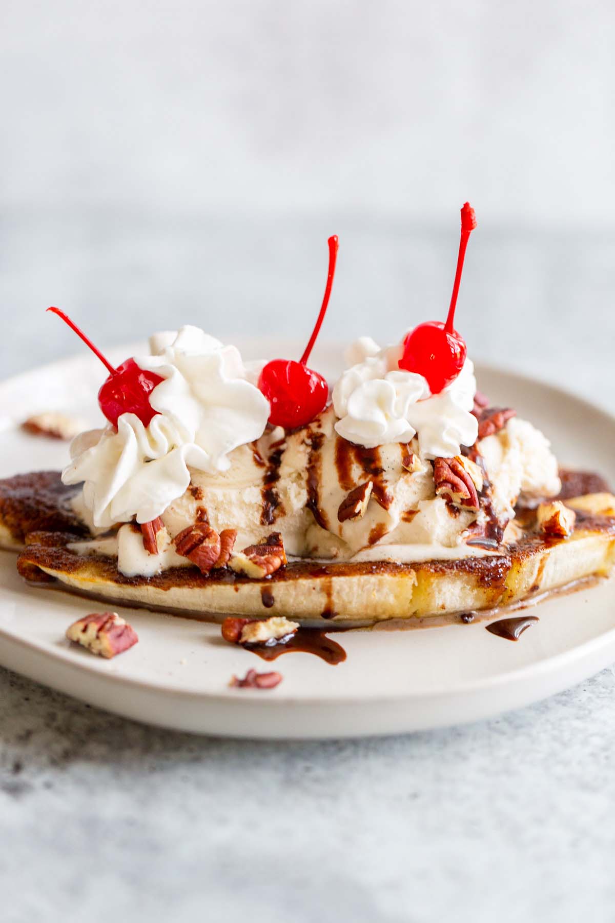 Air fryer banana split with whipped cream and cherries.