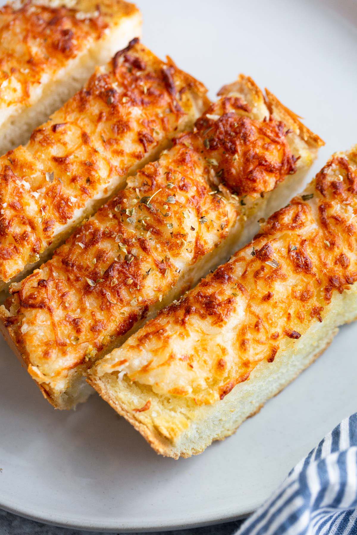 Sliced garlic bread on a plate up close.