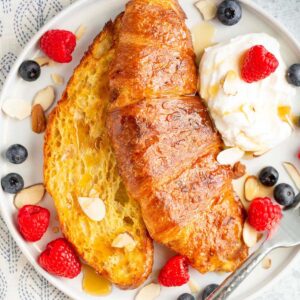 Air fryer croissant french toast with whipped cream and berries.