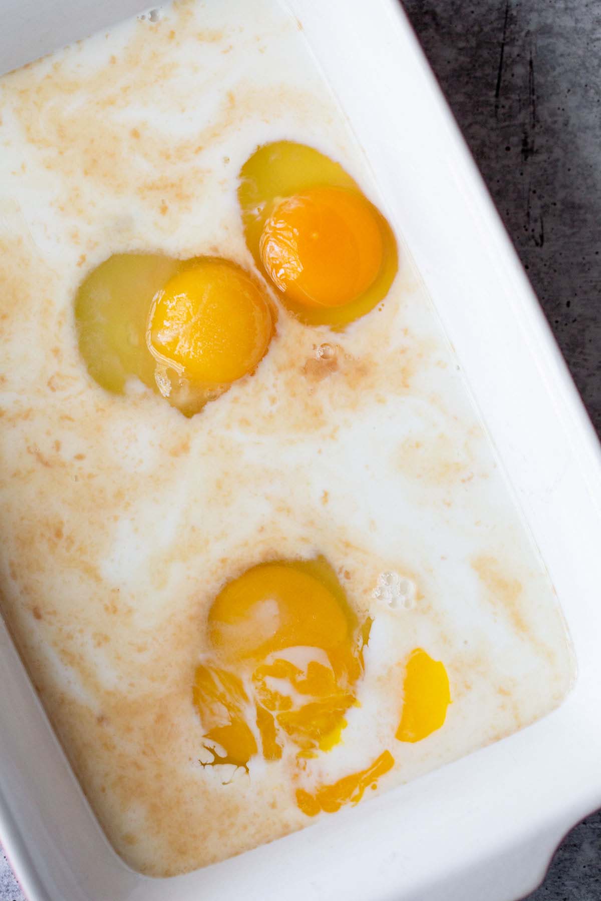 Eggs and milk in a casserole dish.