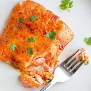 Maple dijon salmon on a plate with fresh parsley.