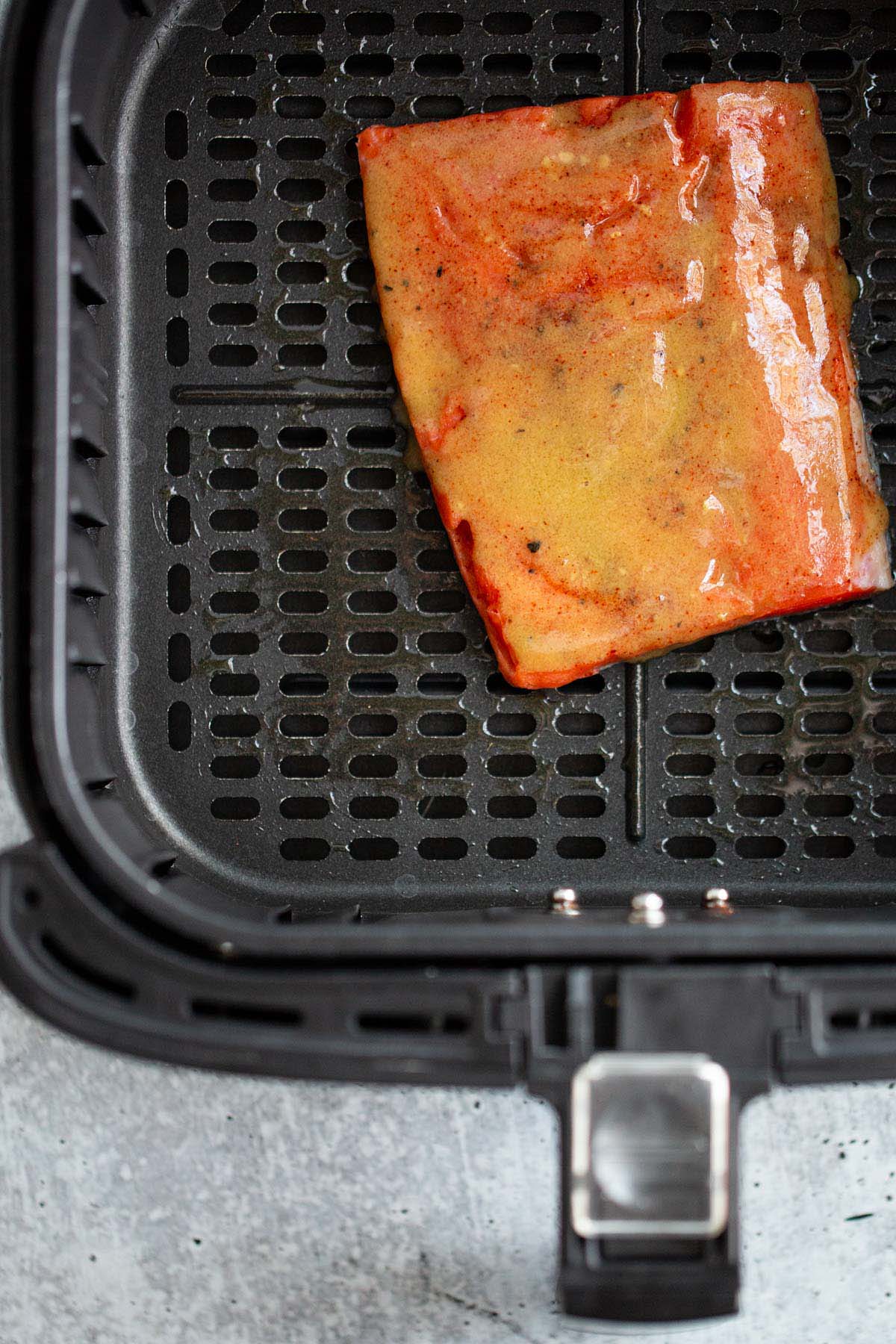 Maple dijon salmon in air fryer basket.