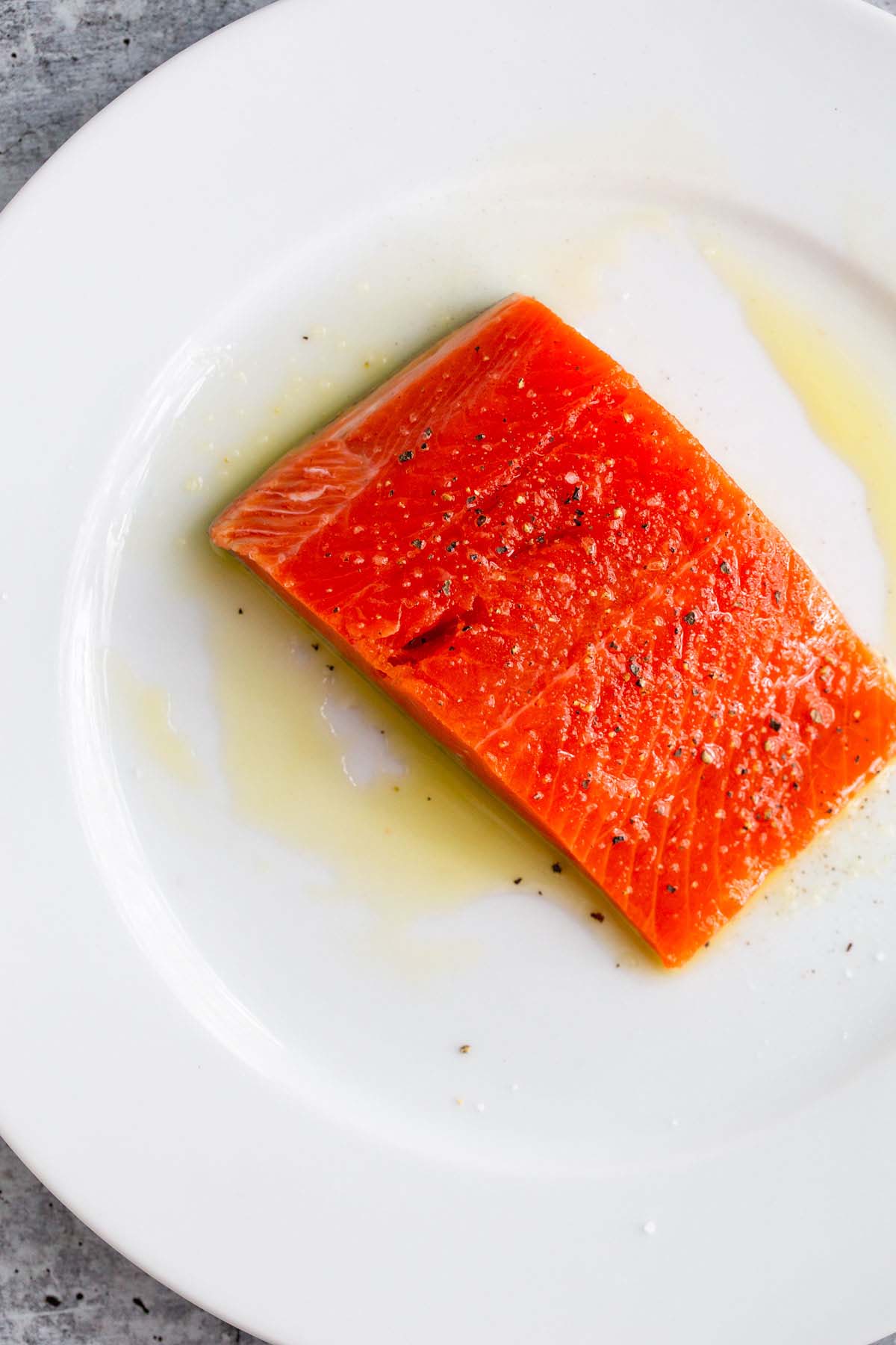 Uncooked salmon on a white plate.