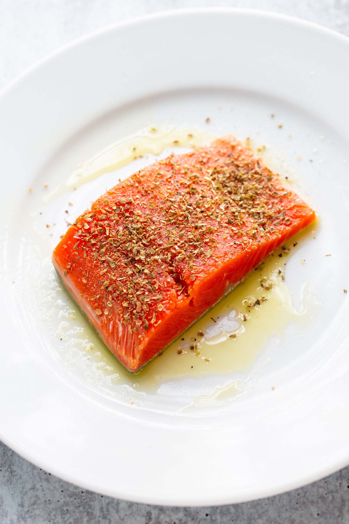 Uncooked salmon seasoned with herbs.