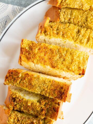 Air fryer pesto garlic bread sliced on a plate.