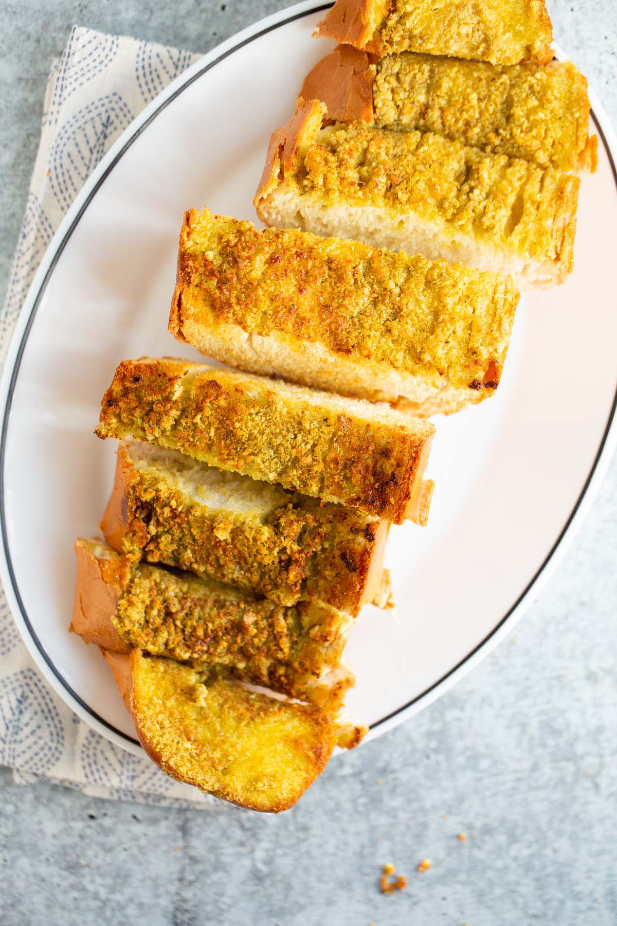 Sliced pesto garlic bread on a plate.