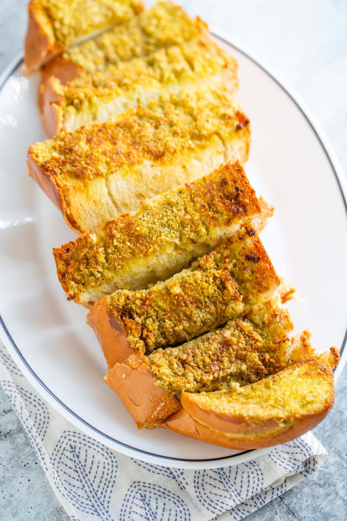 Sliced pesto garlic bread on a plate.