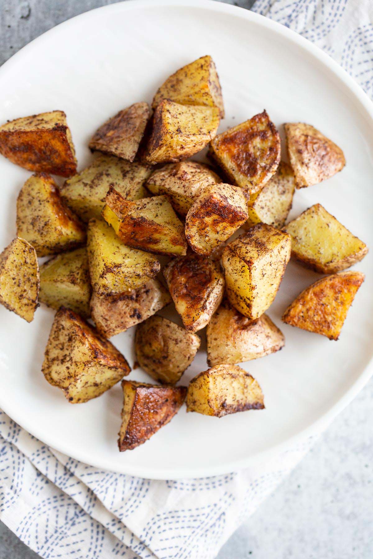 Roasted sumac potatoes on a white plate.