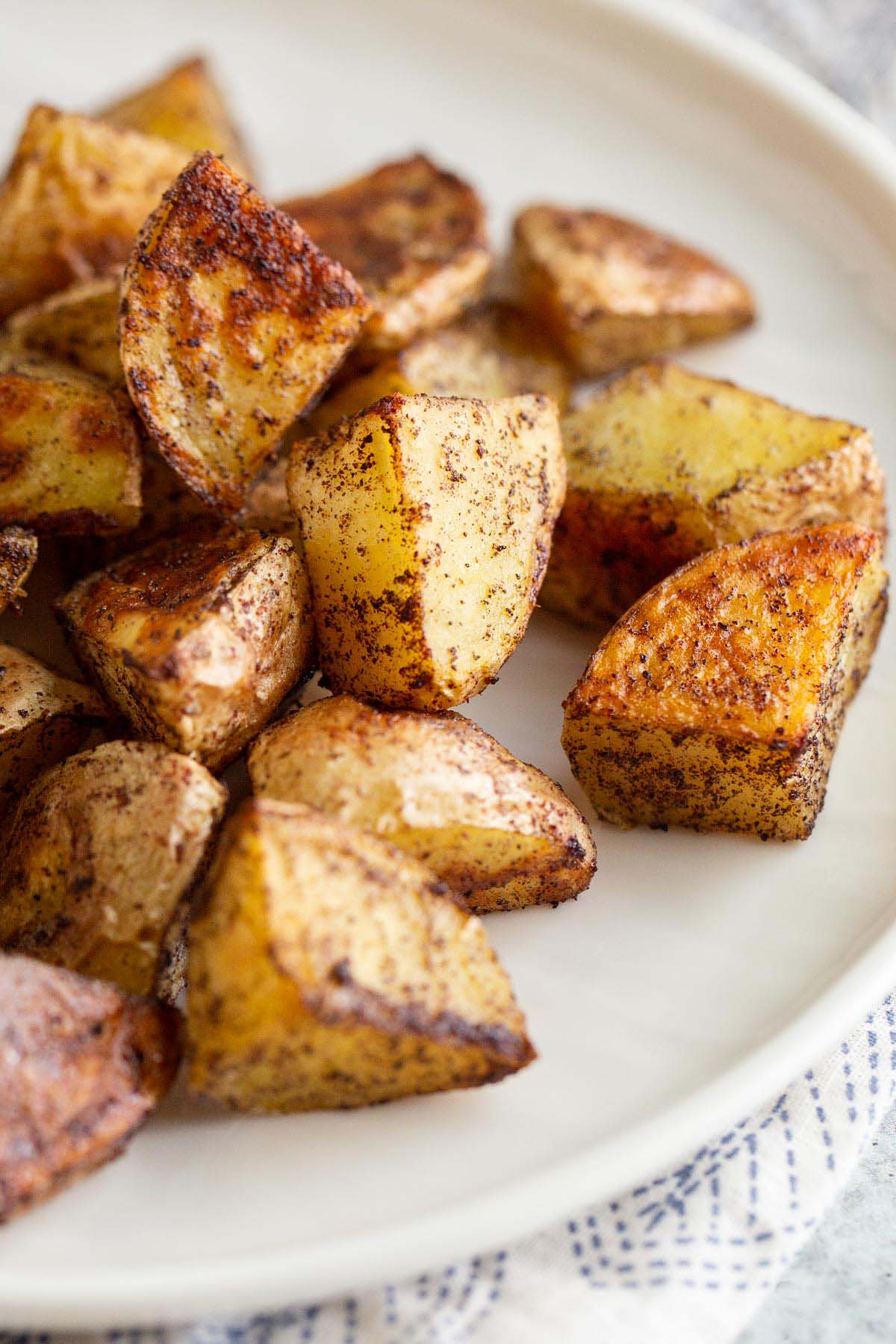 Roasted sumac potatoes on a white plate.