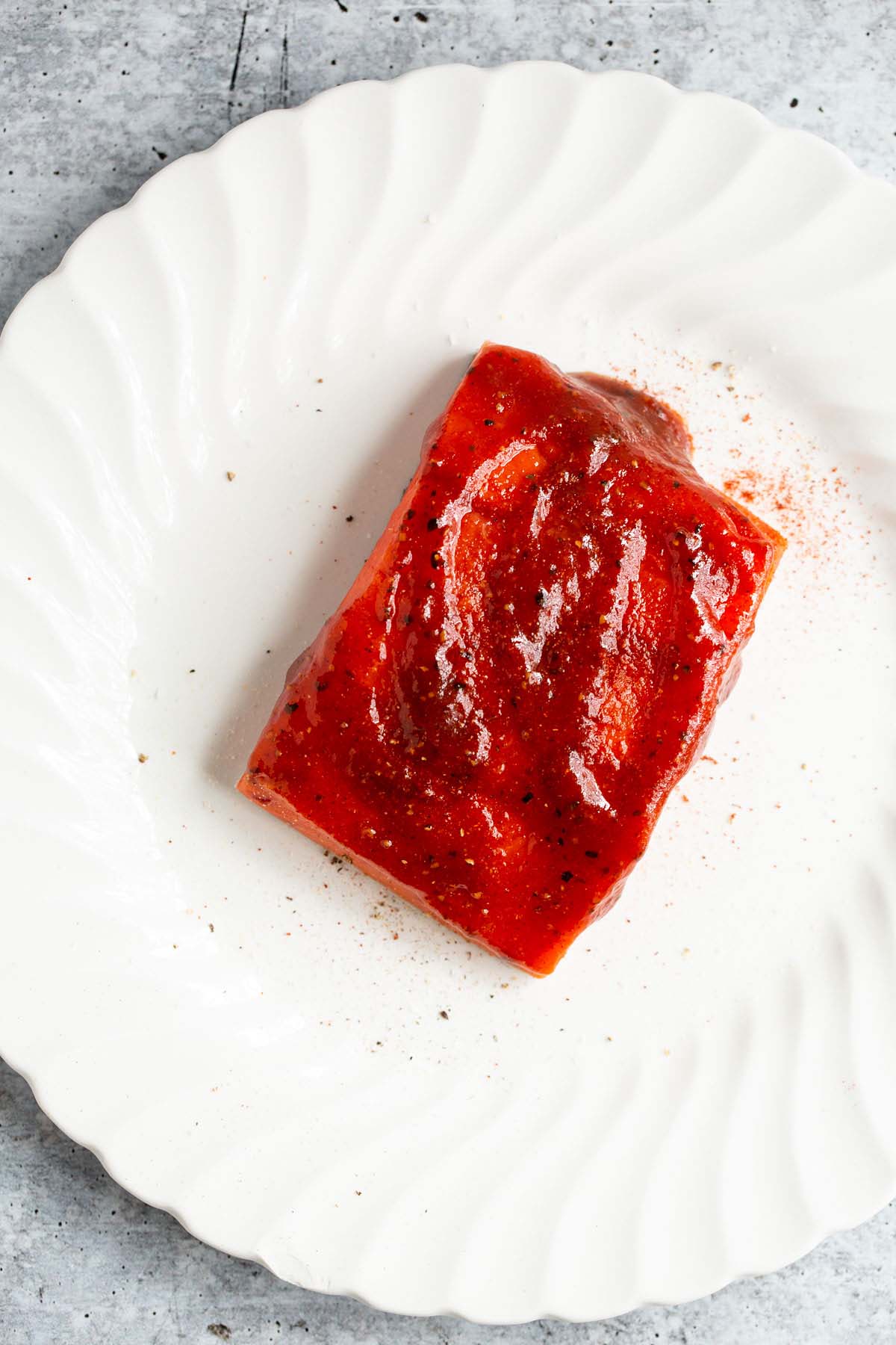 Uncooked bbq salmon on a plate.