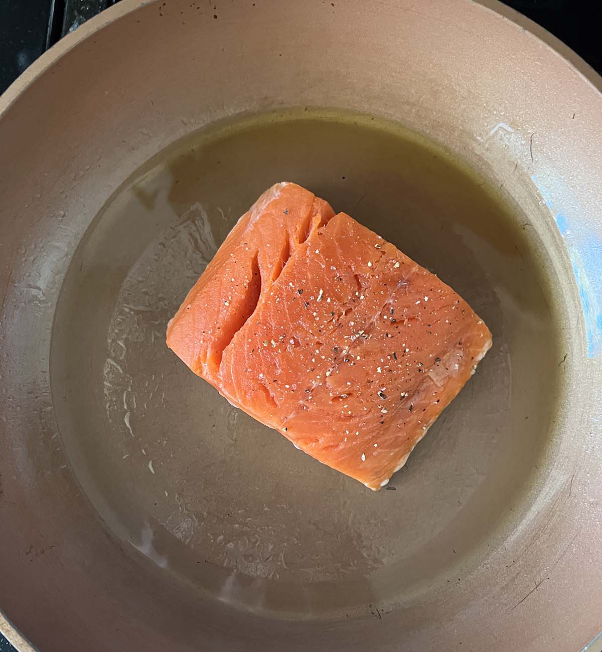 salmon cooking in a skillet.