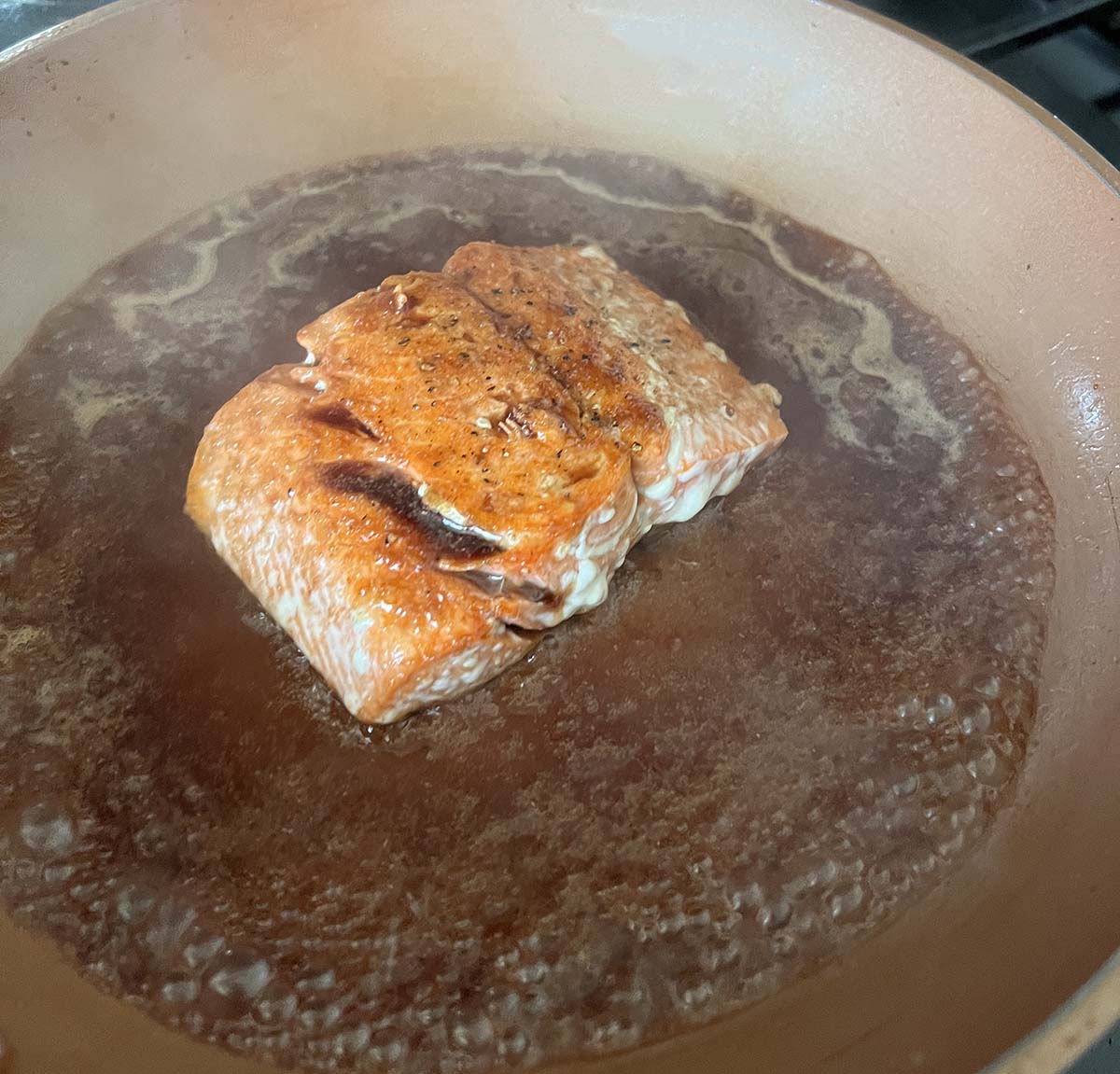 salmon cooking in a skillet.