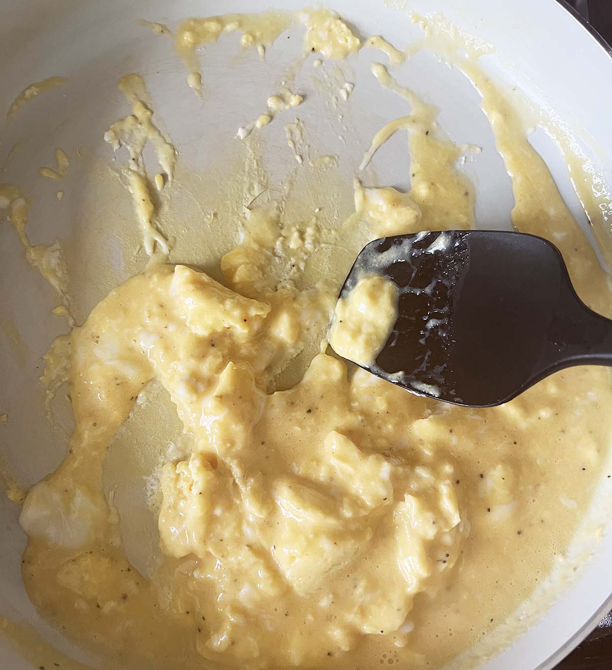 Scrambling eggs in a skillet.