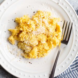 Cacio e pepe scrambled eggs with a fork.