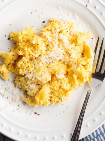 Cacio e pepe scrambled eggs with a fork.