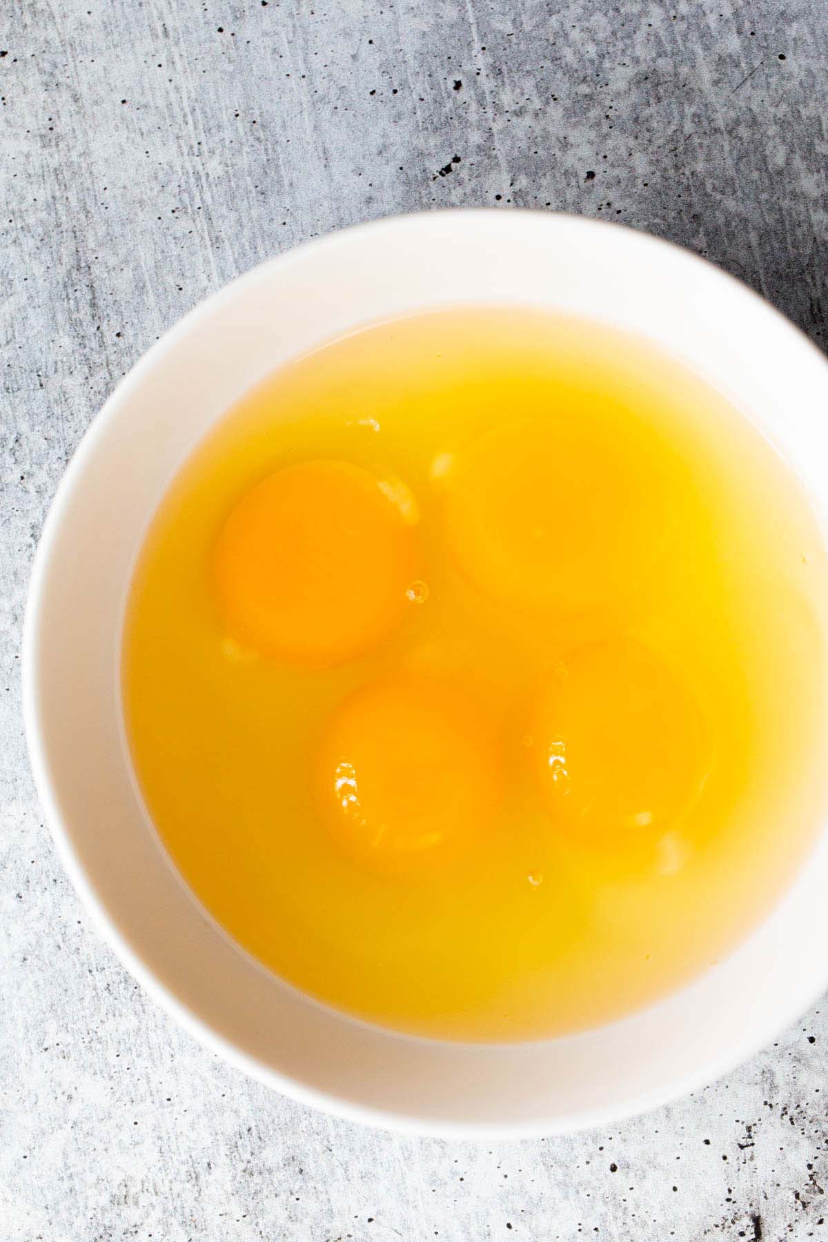 4 raw eggs in a bowl.