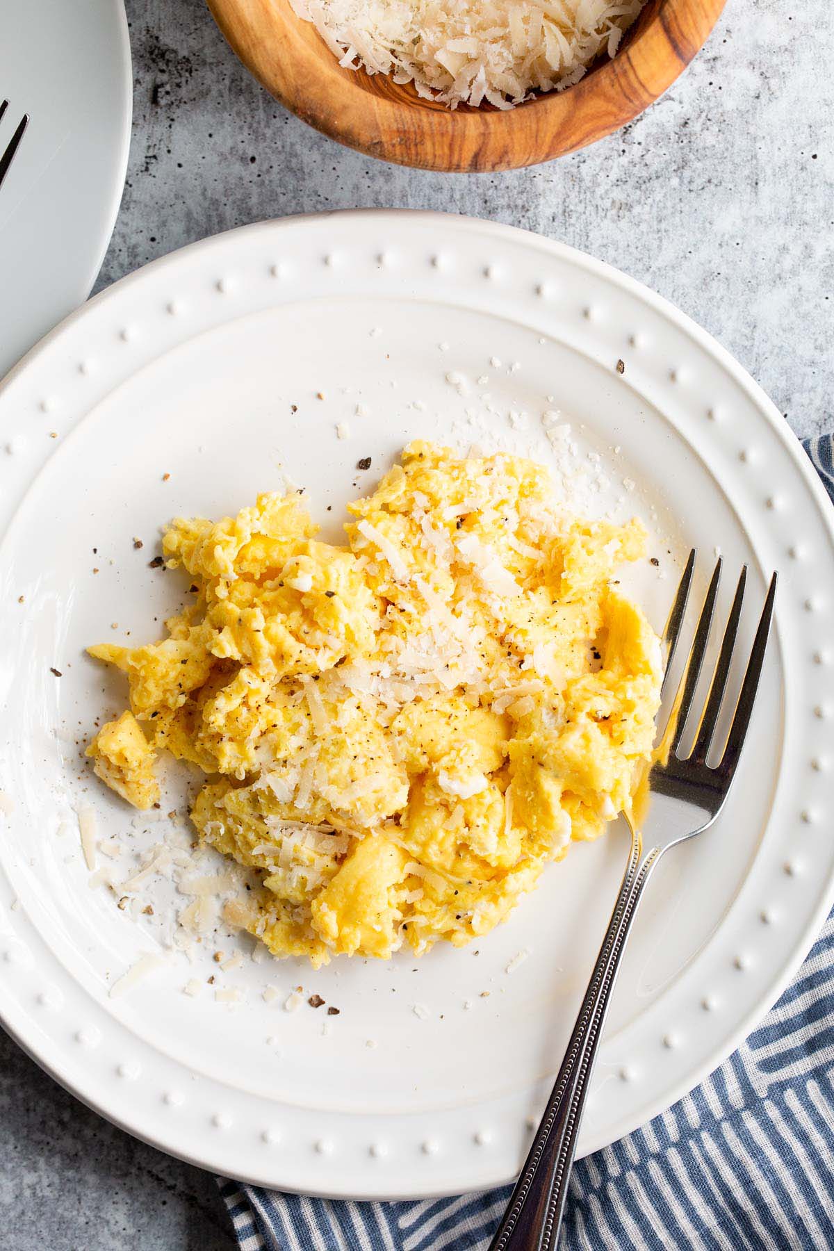 Cacio e pepe scrambled eggs on a white plate.