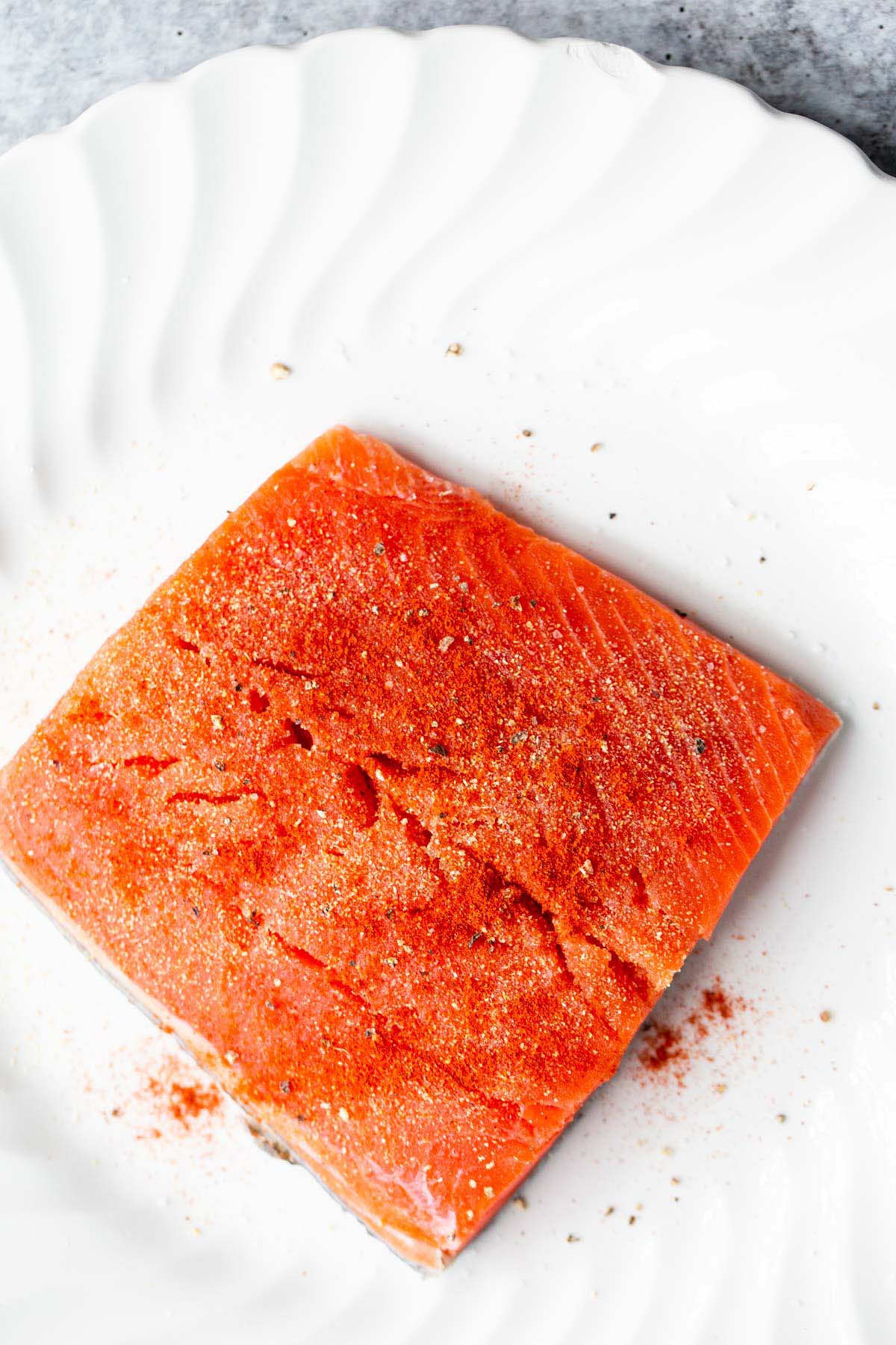 Salmon seasoned with salt, pepper, and spices.