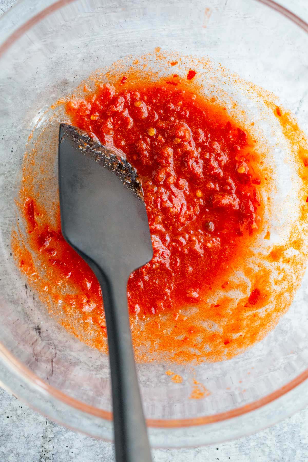 Harissa, lemon juice, and seasonings in a bowl.