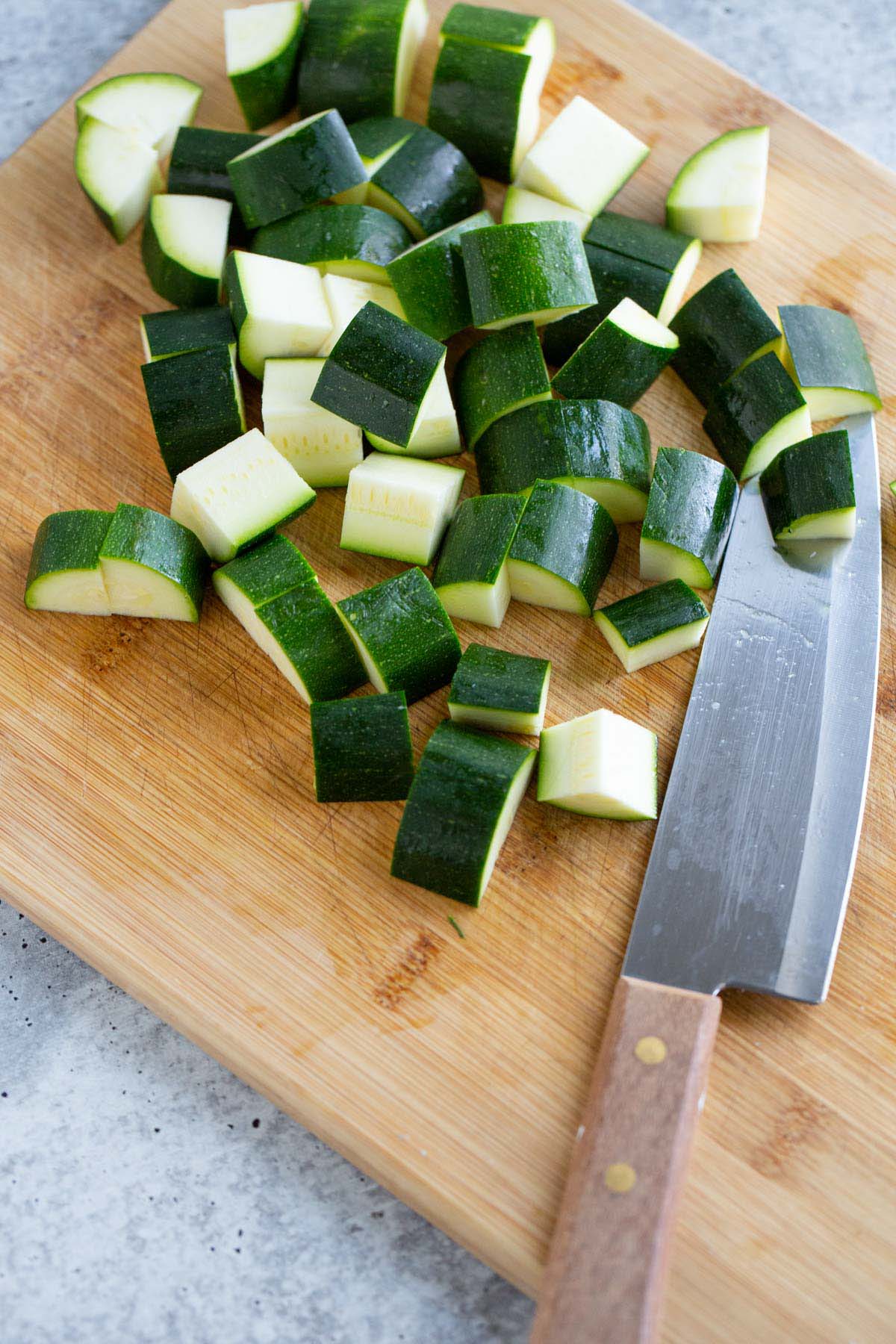 Diced zucchini on a cutting board.