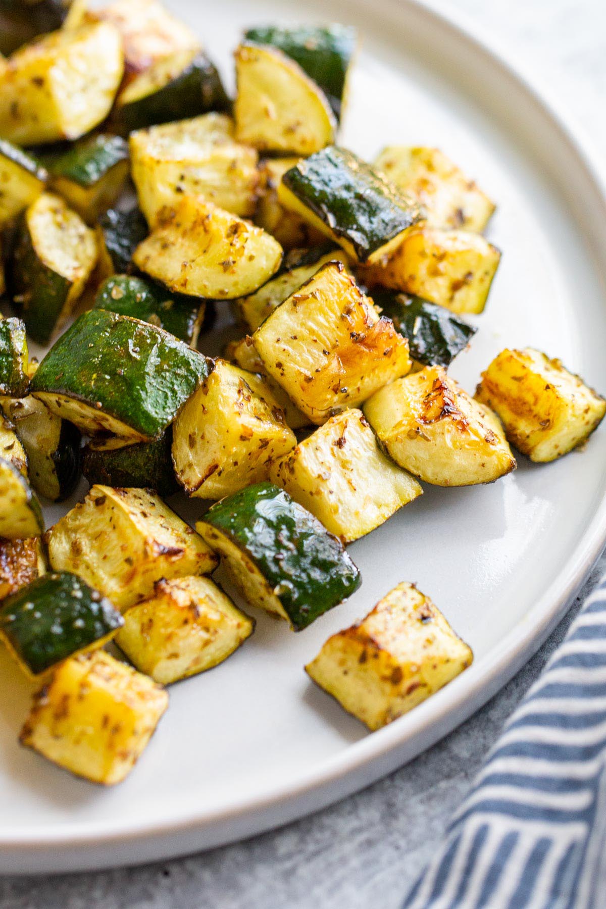 Roasted zucchini on a white plate.