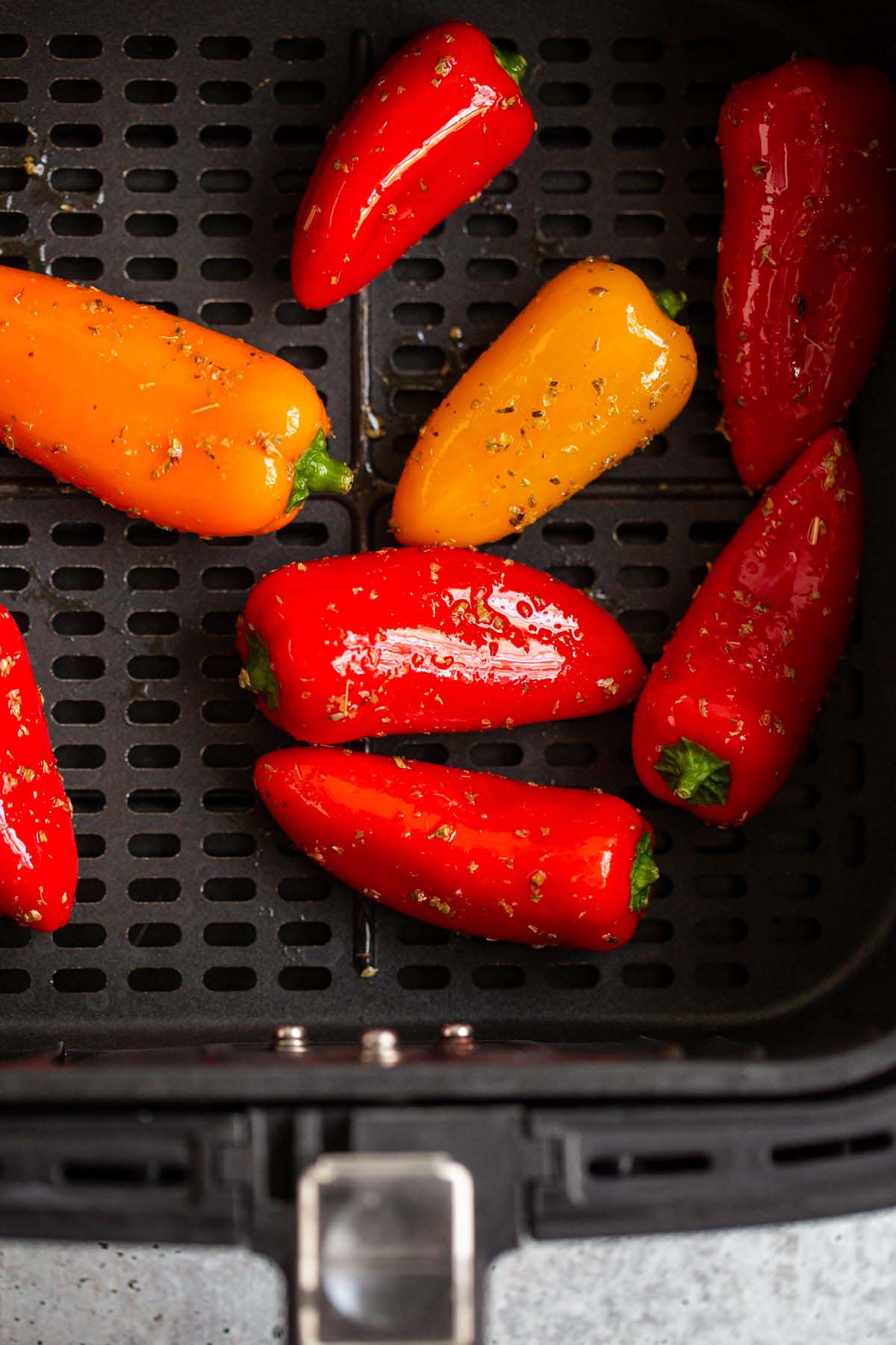 Uncooked mini peppers in air fryer.