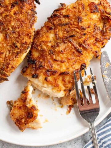 Air fryer crispy onion chicken cut into with a fork and knife.