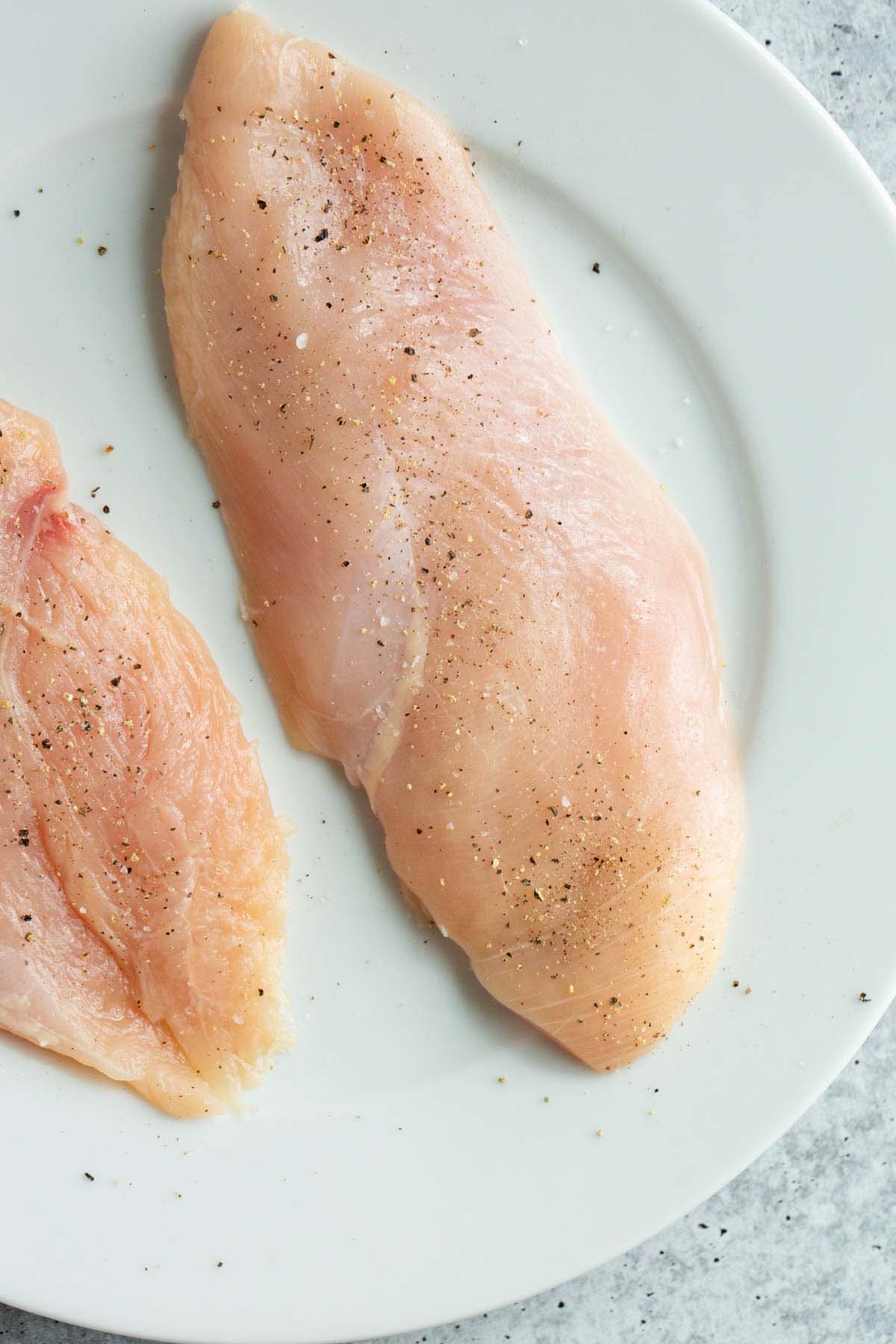 Chicken breast seasoned with salt and pepper.