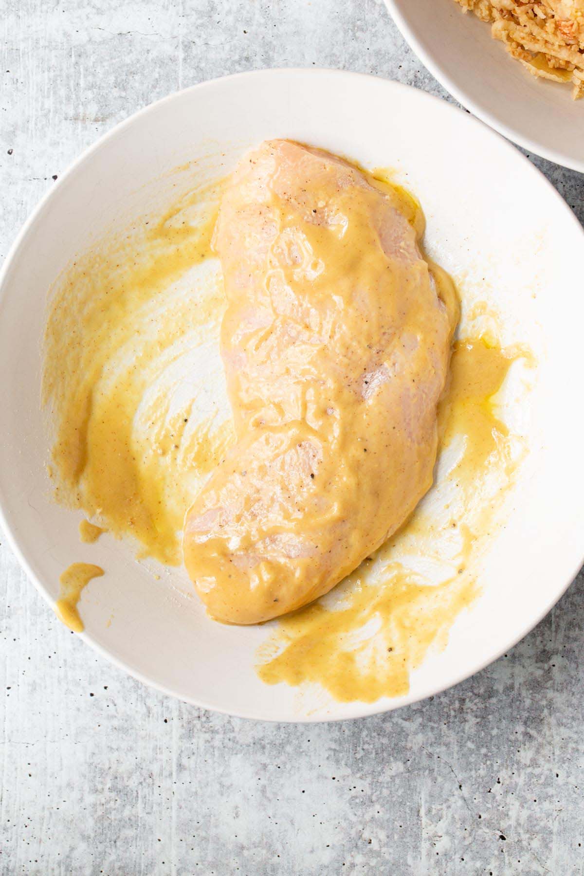 Dipping chicken in honey mustard sauce.
