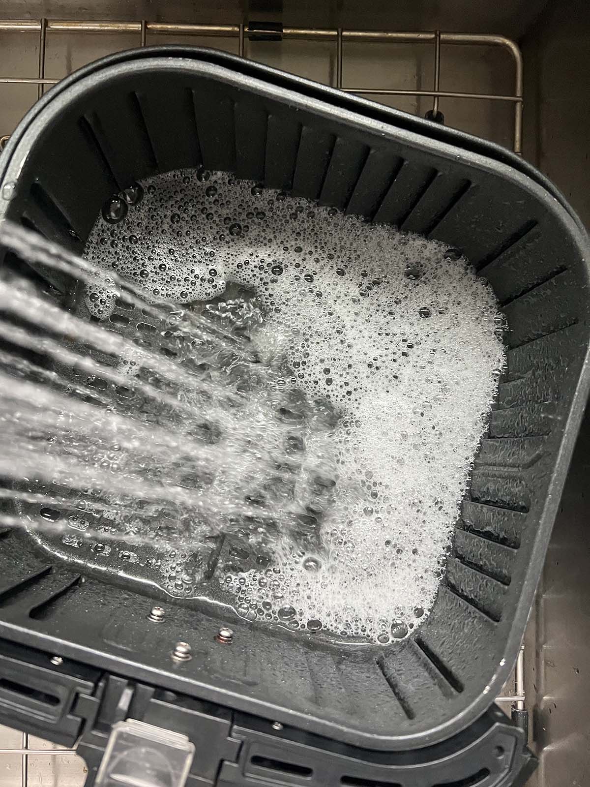 Adding water to air fryer basket.