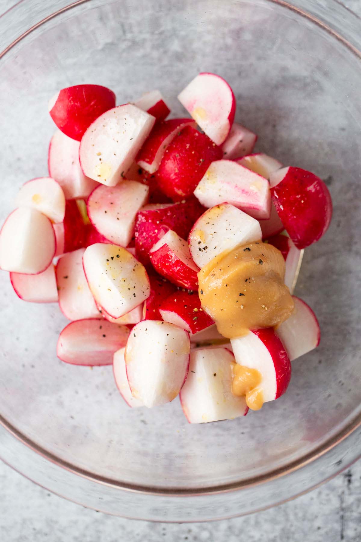 Radishes in a bowl with miso, sesame oil, and olive oil.