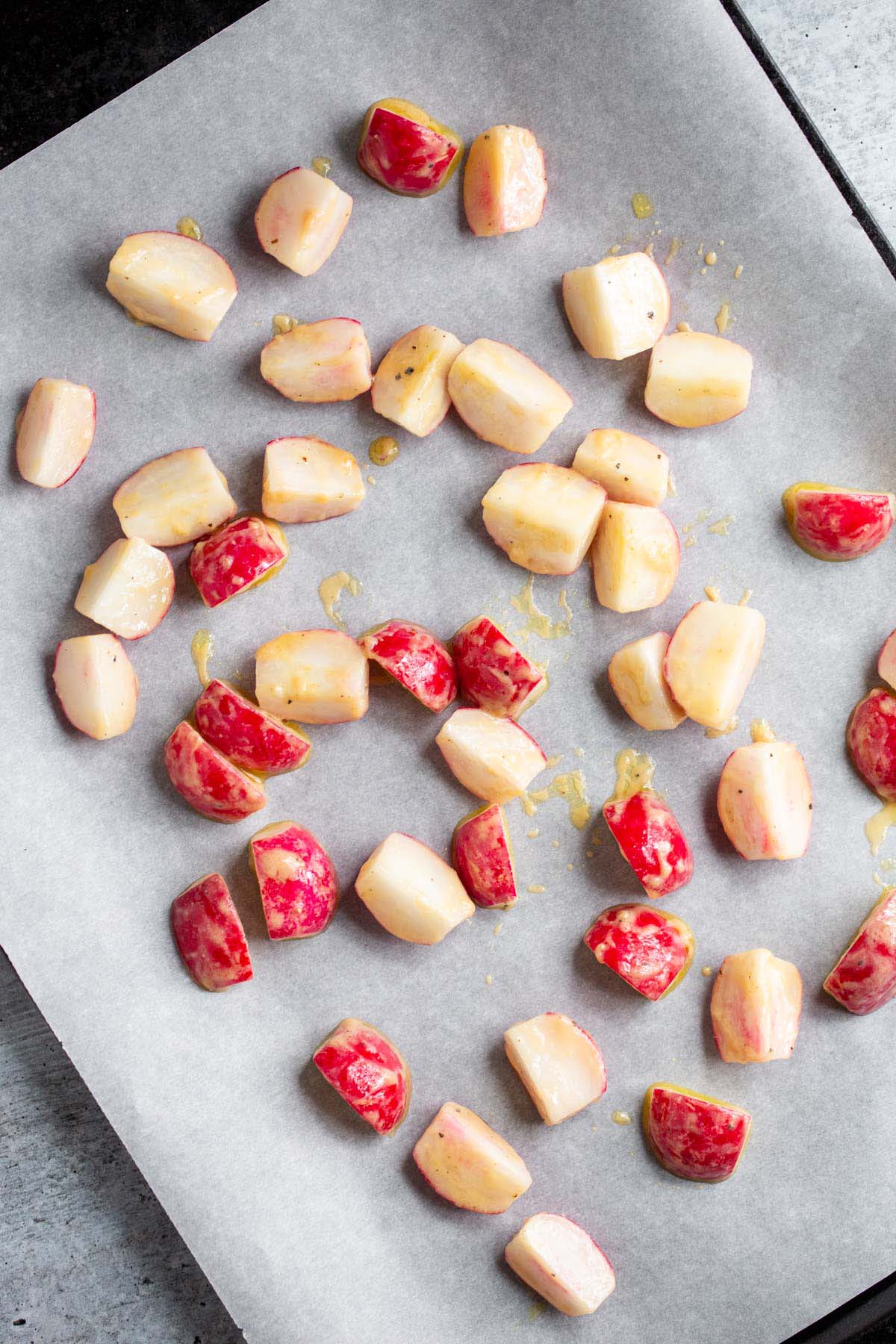 Uncooked radishes on baking sheet.