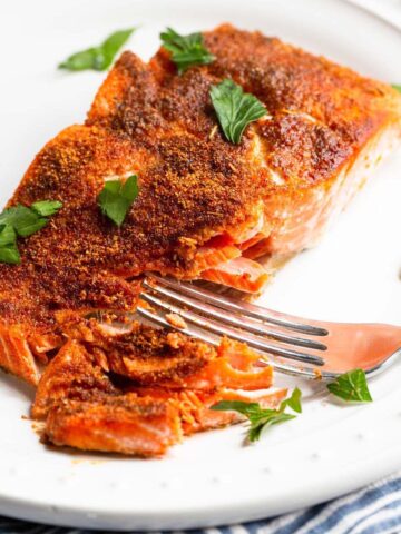 Air fryer blackened salmon on a white plate.