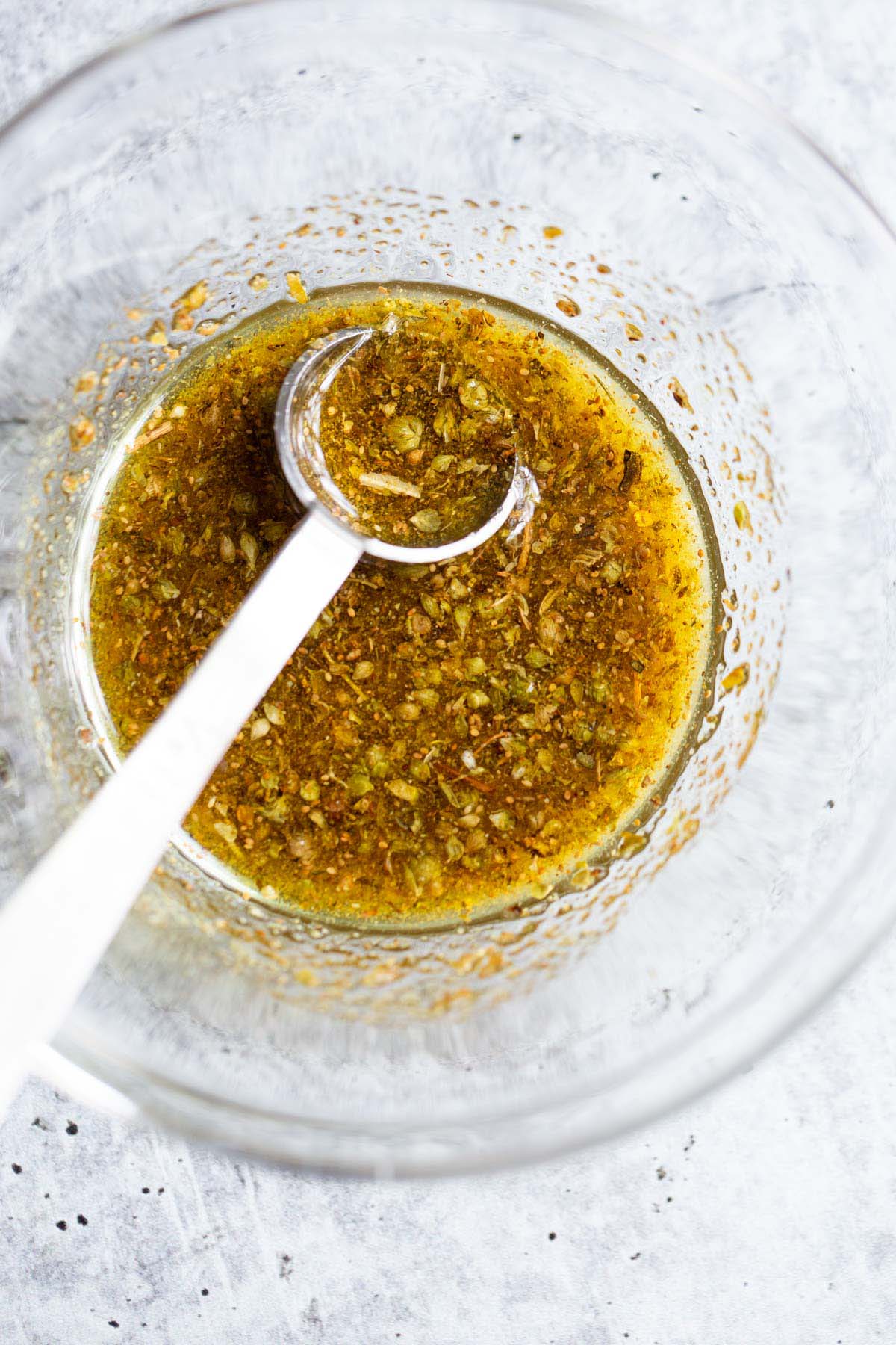 Herbs and olive oil mixed in a bowl.