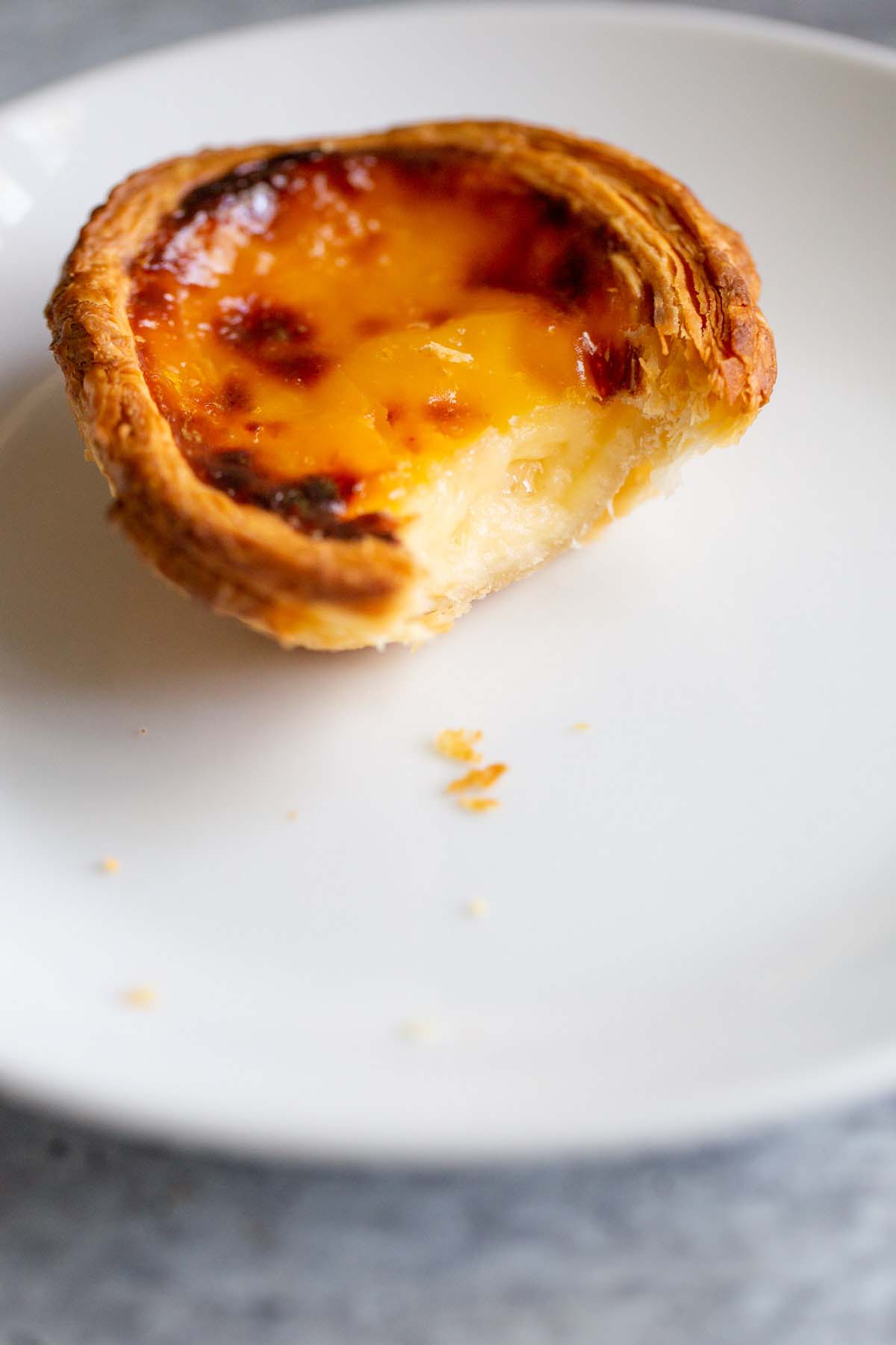 Custard tart with a bite taken out of it.