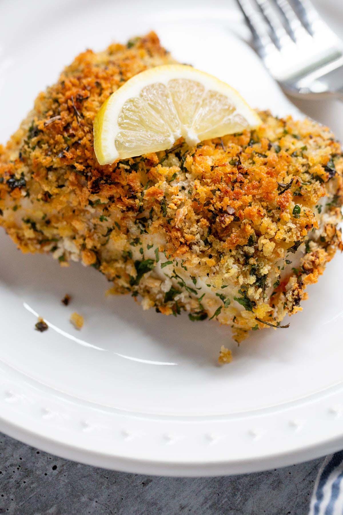 Air fried panko cod with a wedge of lemon on top.