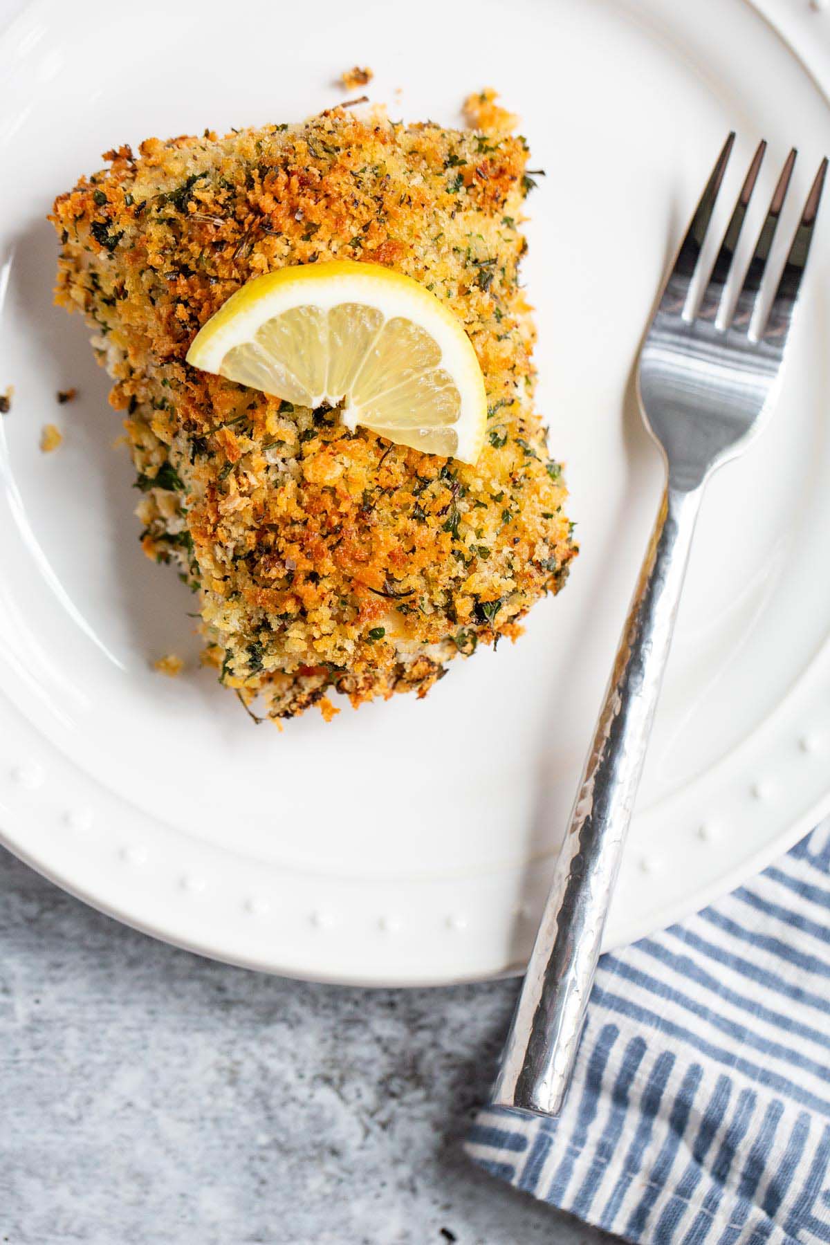 Air fried panko cod with a wedge of lemon on top.