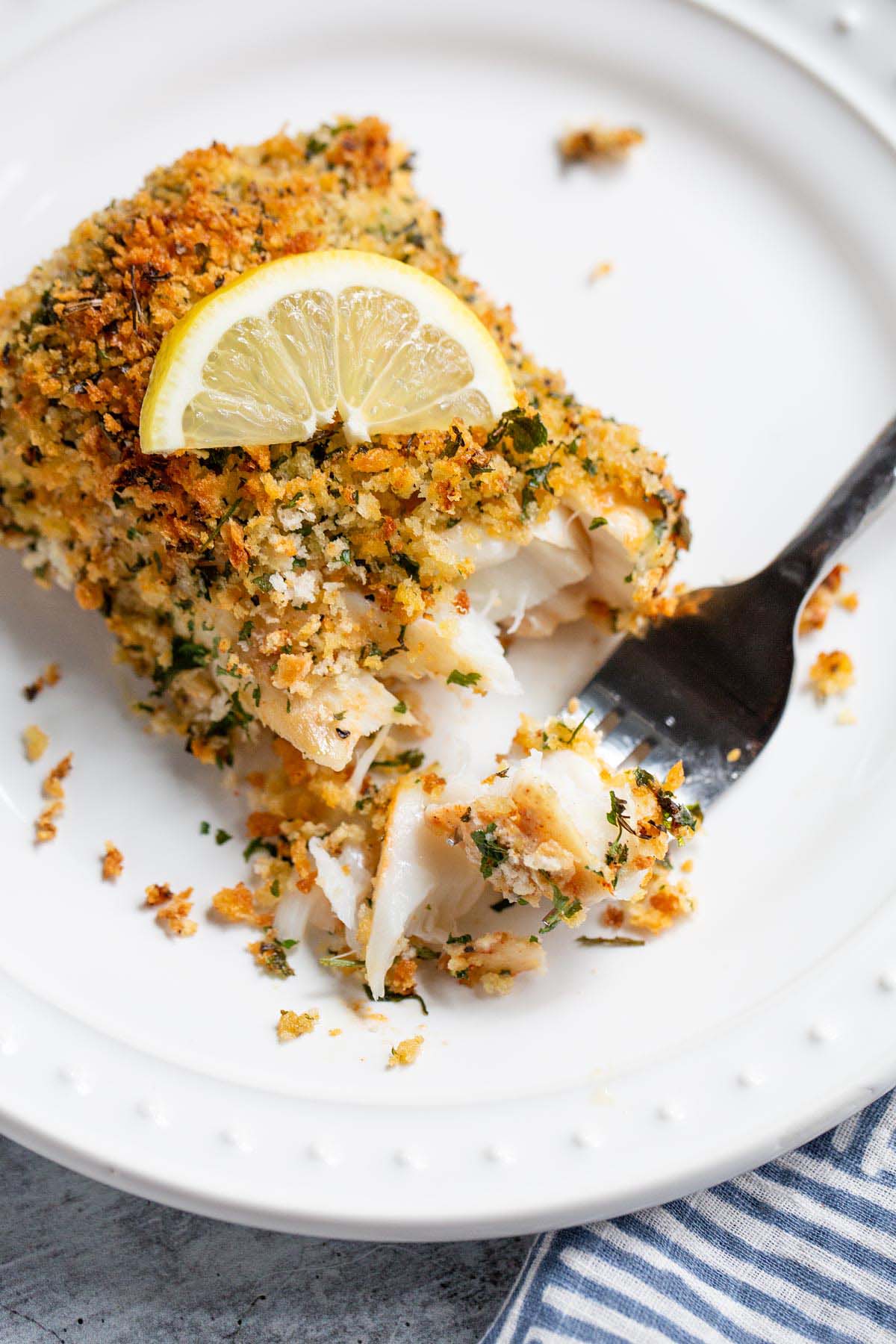 Air fried panko cod with a wedge of lemon on top.