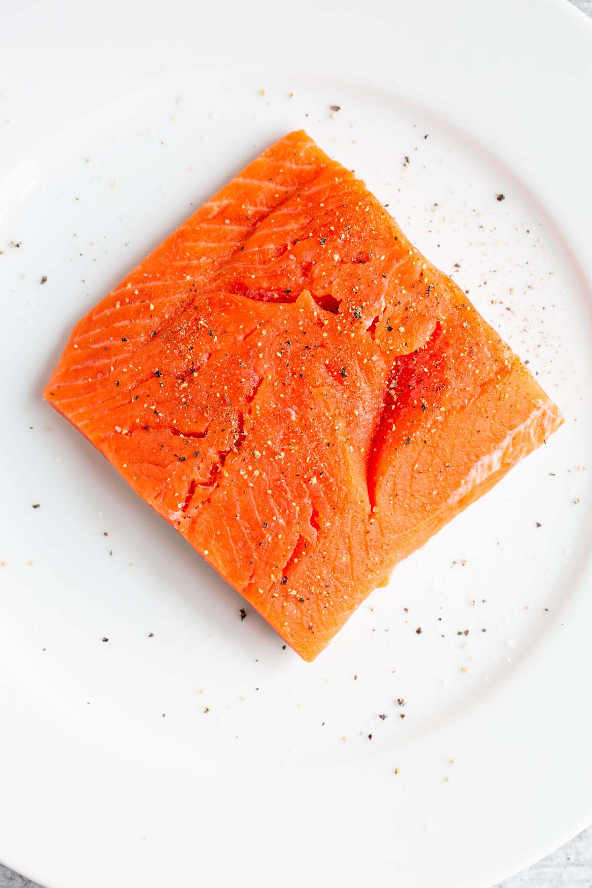 Raw salmon on a white plate.