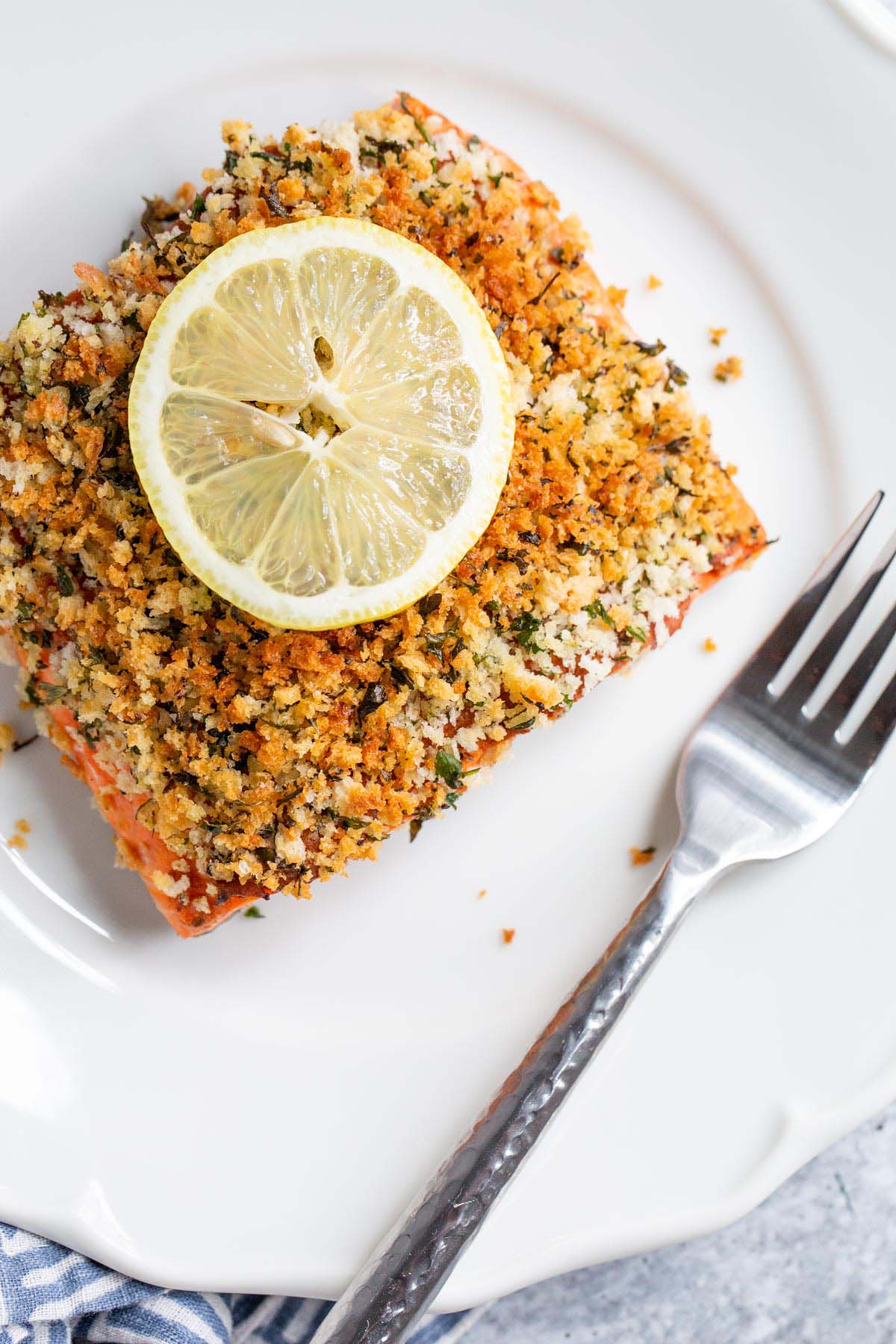 Panko crusted salmon on a plate with a lemon slice.