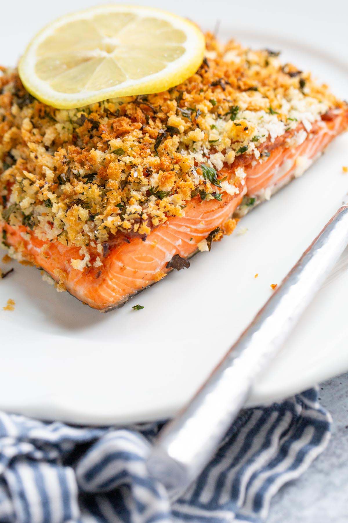 Panko crusted salmon on a plate with a lemon slice.