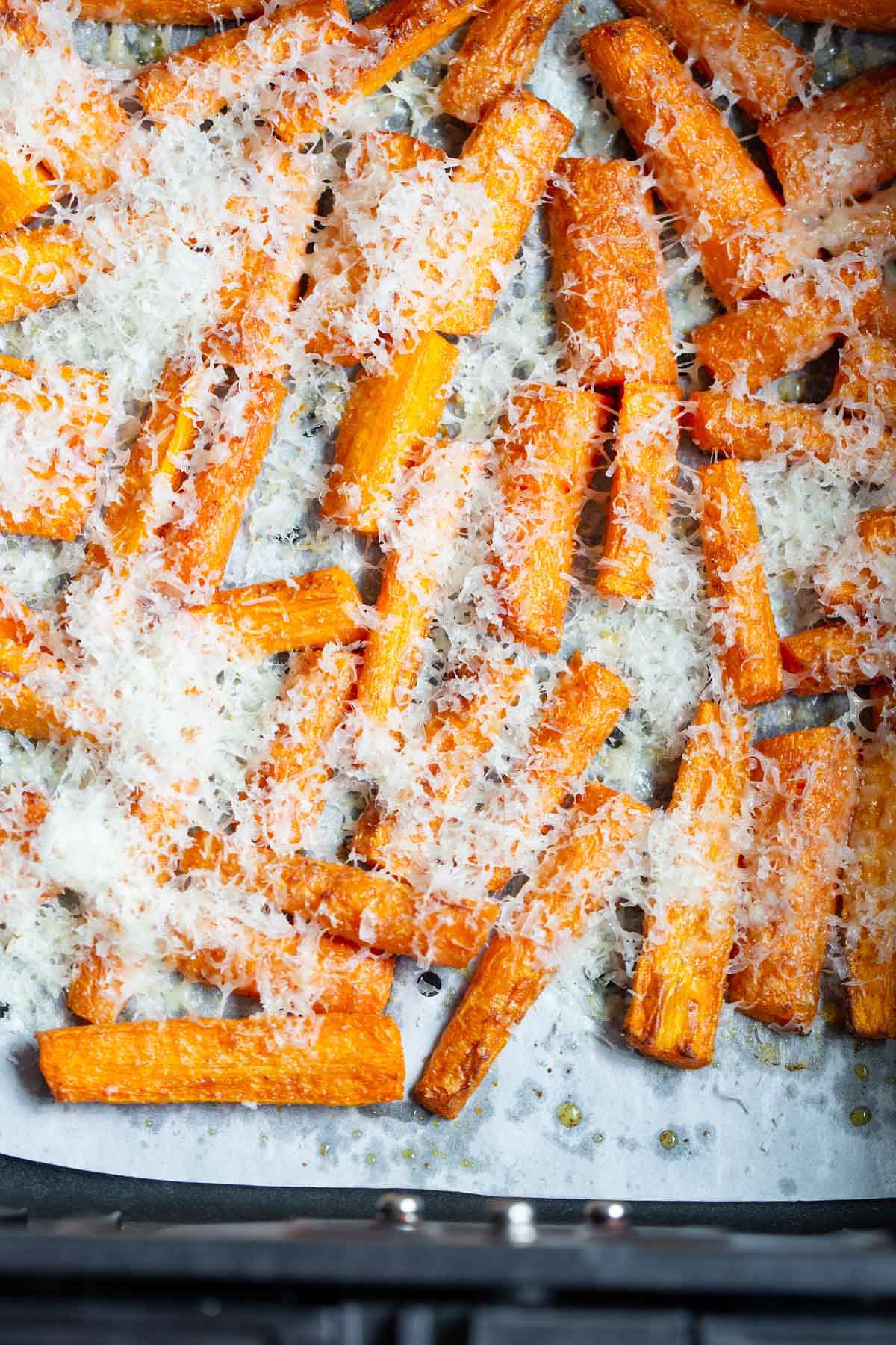 Carrots in air fryer topped with parmesan.
