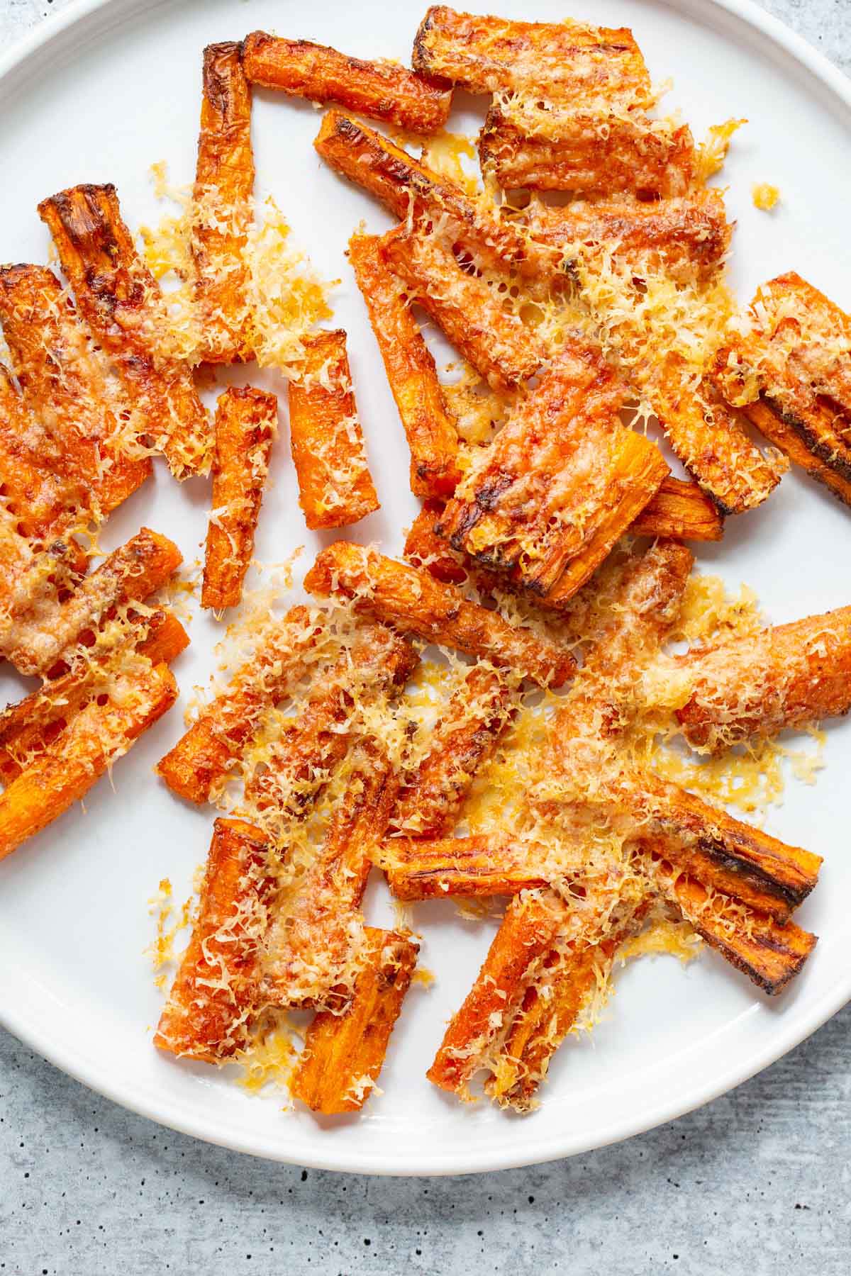 Parmesan carrots on a white plate.