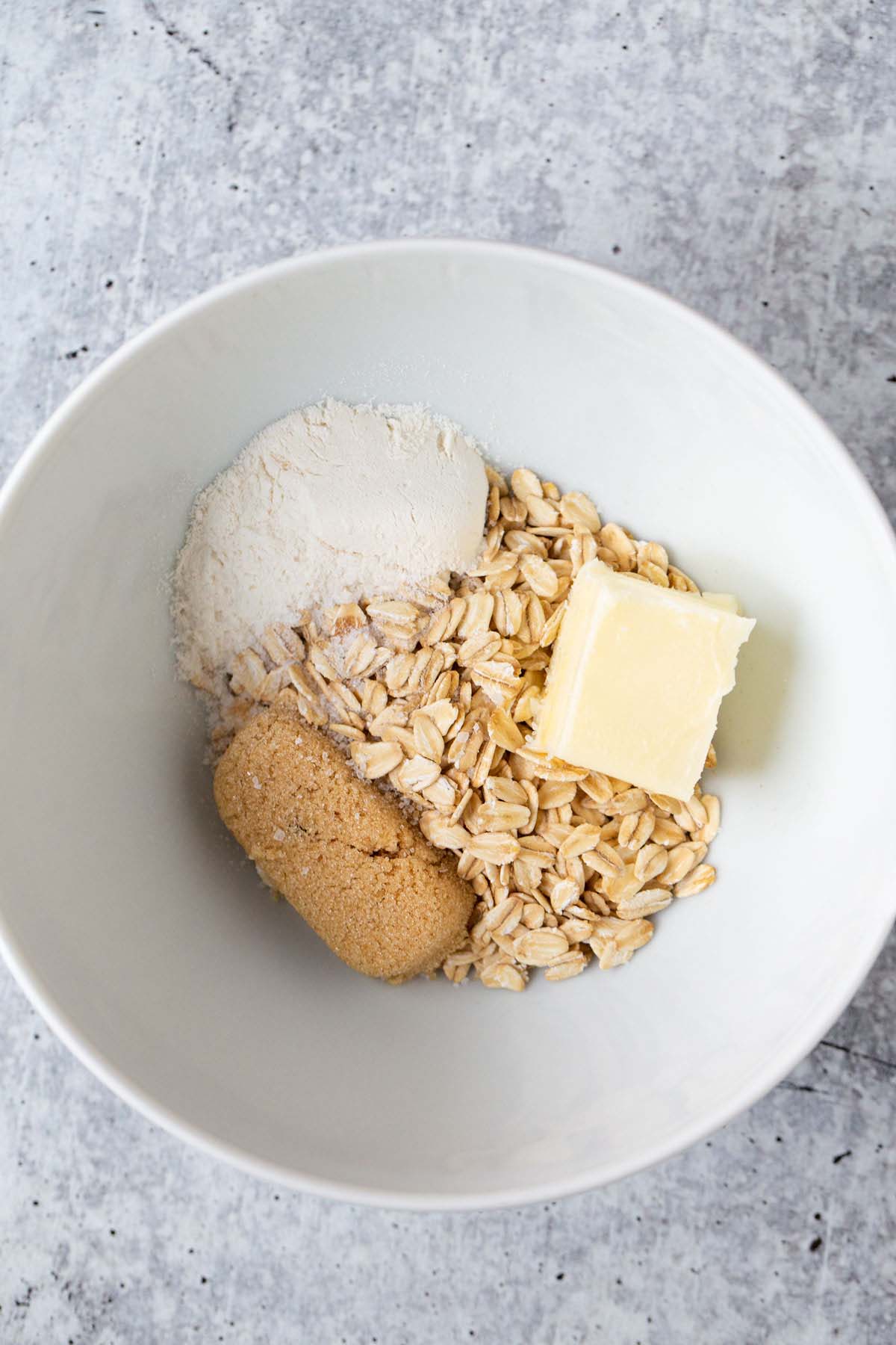 Oats, brown sugar, butter, and flour in a bowl.