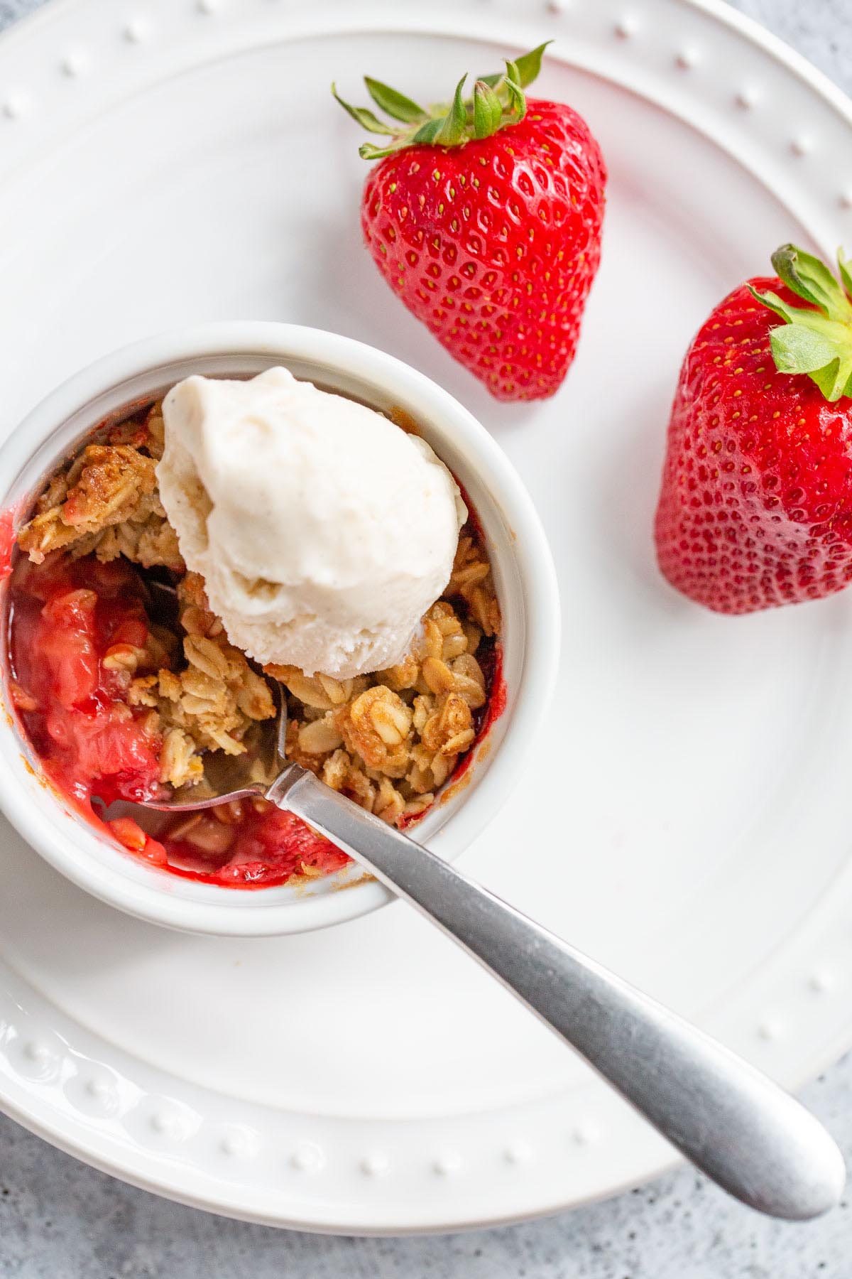 Air fryer strawberry crisp with a scoop of ice cream.