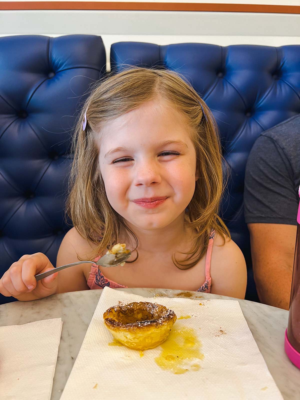 Girl eating Pastel de Nata.