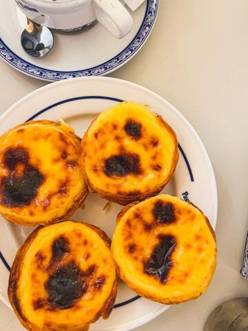 Four pastel de nata on a plate from Pasteis de Belem.