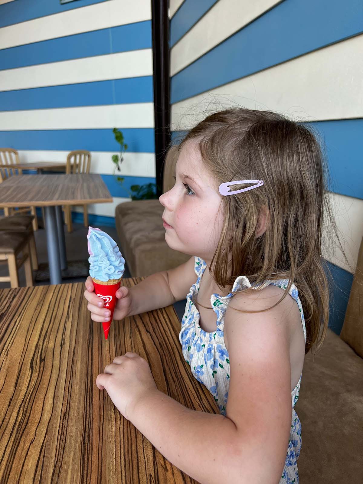 Girl eating an ice cream cone.