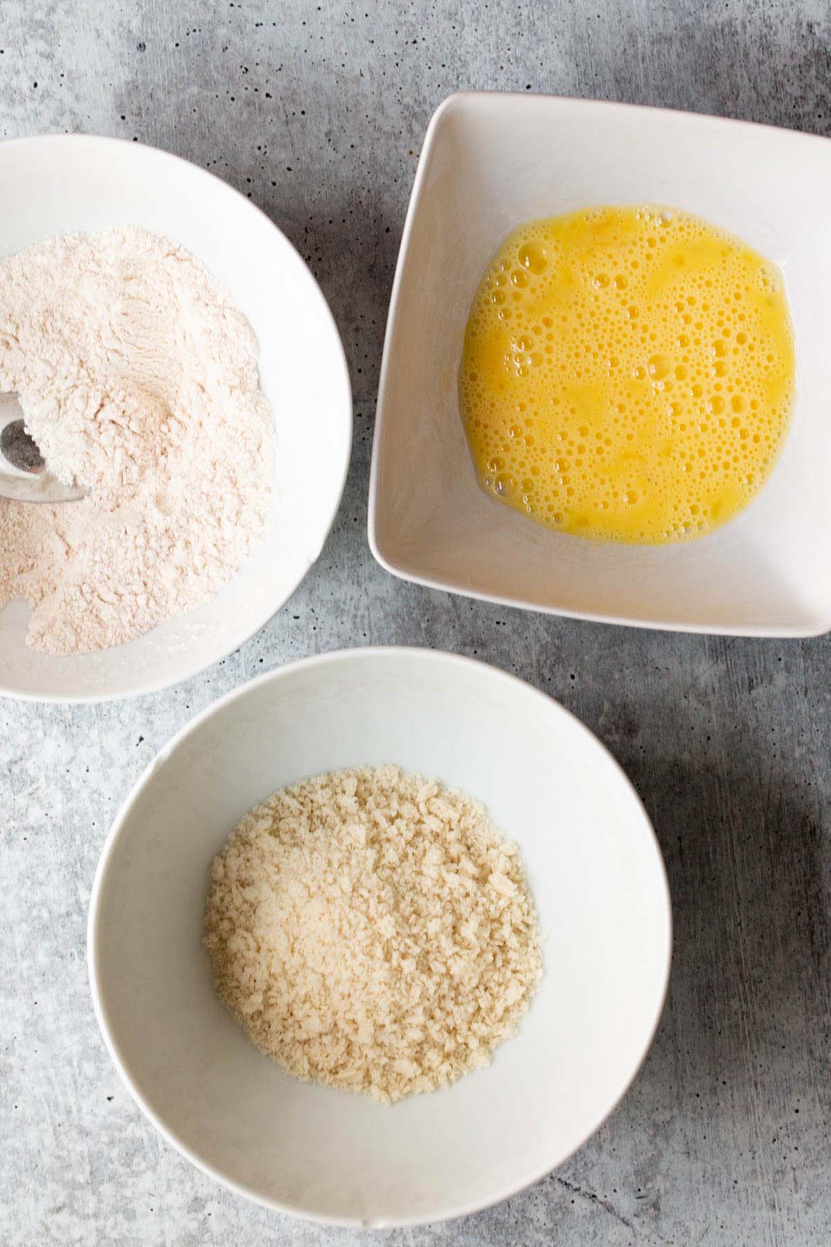 different bowls with egg, flour, and panko